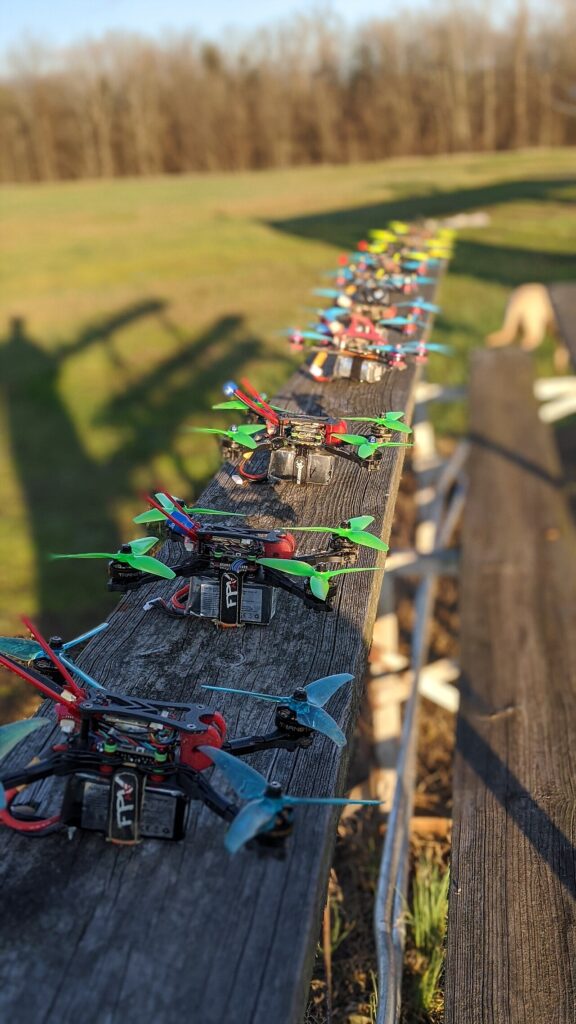 Ряд гоночных FPV-дронов с яркими печатными деталями